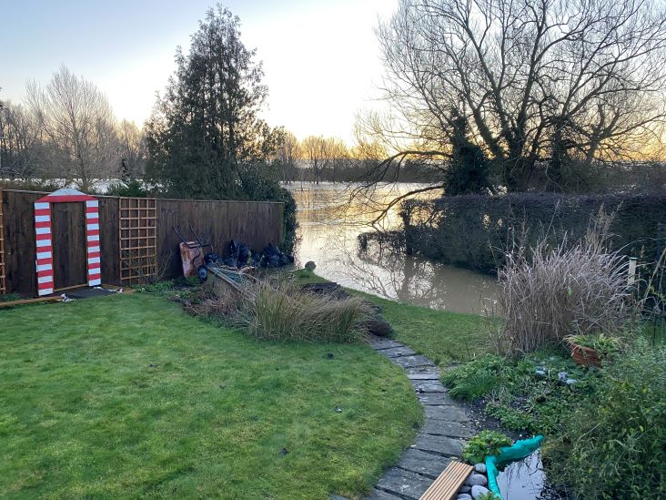 Fast-flowing flood waters creep up Manorfields Rd gardens, 2020